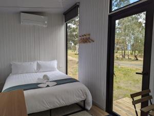 a bedroom with a bed with a bow on it at Tiny House 15 at Grampians Edge in Dadswells Bridge