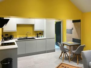 a kitchen with white cabinets and a table with chairs at Peartree Cottage in Sheffield