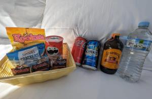 a basket of snacks and bottles of water on a bed at Tiny House 19 at Grampians Edge in Dadswells Bridge