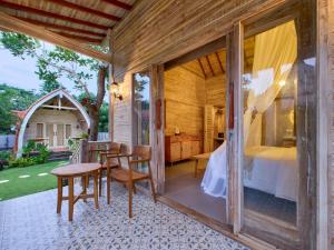 a room with a bed and a table and chairs at Uluwatu Desa in Uluwatu