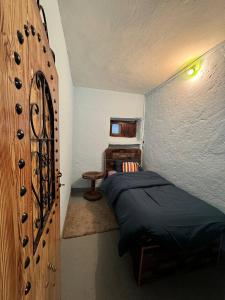 1 dormitorio con 1 cama y pared de madera en Gîte de montagne Azilane, en Izilane