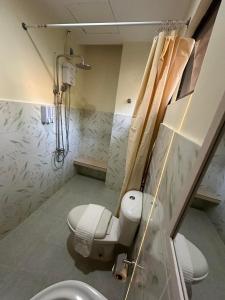 uma casa de banho com um chuveiro, um WC e um lavatório. em Desert Rose Beach Hotel em El Nido