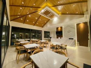 - un restaurant avec des tables et des chaises dans une salle dans l'établissement Cocotree Resort, à Panglao