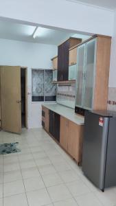 a kitchen with wooden cabinets and a stainless steel refrigerator at Eing's Homestay - Muslim And Mahram Only in Kajang
