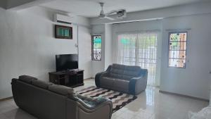 a living room with a couch and a tv at Eing's Homestay - Muslim And Mahram Only in Kajang