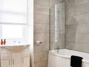 a bathroom with a tub and a sink at Main Street Flat A - Uk46448 in Ayr