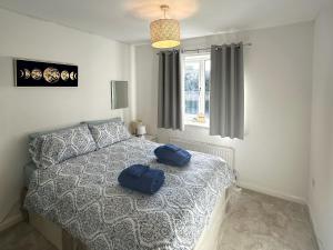 a bedroom with a bed with two blue pillows on it at Cousens House in Dawlish