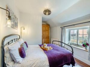 sypialnia z łóżkiem z fioletowym kocem w obiekcie Lavender Cottage w mieście Heacham