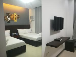 a hotel room with two beds and a flat screen tv at Le Vita Hotel in Santo Domingo