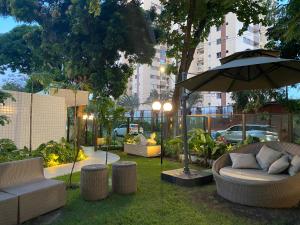 een tuin met stoelen, een parasol en een tafel bij Apt novíssimo Tamarineira in Recife