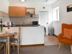 a kitchen and dining room with a table and chairs at Contention Barn in Perranporth