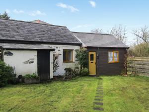 a small house with a yellow door in a yard at Contention Barn in Perranporth