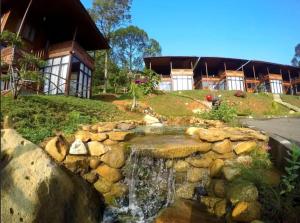 un estanque frente a una casa con cascada en Gunung Geulis Camp Area, en Pasirkuda