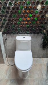a toilet in a bathroom with a wall of bottles at Nature Hill in Koh Mook