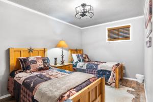 a bedroom with two beds and a chandelier at Salt Block - The Rustic Suite 1 in Bandera