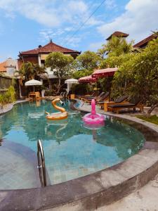 uma piscina com um macarrão de piscina num resort em Berlian Inn Kuta Beach em Kuta