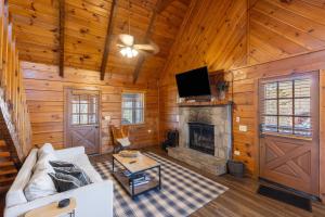 a living room with a couch and a fireplace at Dudley II by AvantStay Comfortable Cabin w Hot Tub Views in Pigeon Forge