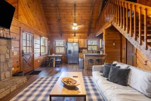 a living room with a couch in a log cabin at Dudley II by AvantStay Comfortable Cabin w Hot Tub Views in Pigeon Forge