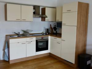 uma cozinha com armários brancos e um forno com placa de fogão em Wohnung an der Bocksmauer em Osnabrück