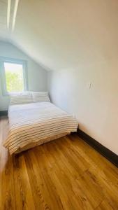 uma cama num quarto com piso em madeira em Farm View & Close Lake & Steam Sauna & 10 Acres em Stouffville