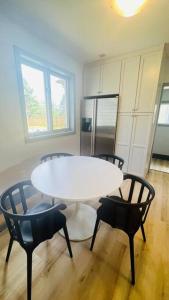 uma mesa branca e cadeiras num quarto com um frigorífico em Farm View & Close Lake & Steam Sauna & 10 Acres em Stouffville