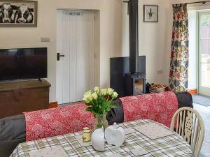 a living room with a table and a fire place at Bramley - Uk37378 in Pilton