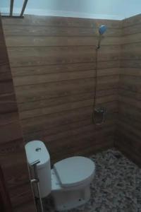 - Baño con aseo y pared de madera en Gunung Geulis Camp Area, en Pasirkuda