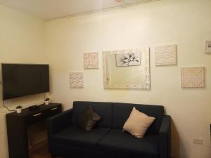 a living room with a couch and a flat screen tv at Grandiose Domicile in Basak