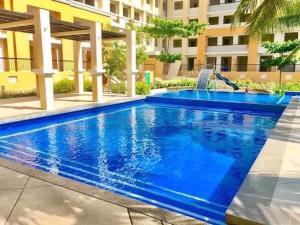 a swimming pool at a hotel with a blue swimming pool at Grandiose Domicile in Basak