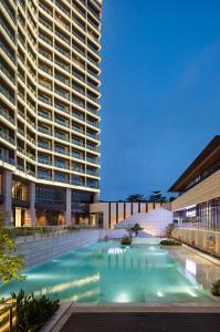 a swimming pool in front of a tall building at Prince Times Hotel in Sihanoukville