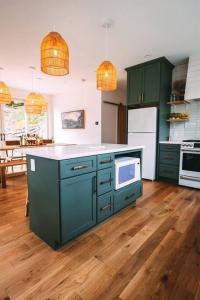 una cocina con armarios verdes y electrodomésticos blancos en Dunlap Hollow A-Frame en Rockbridge