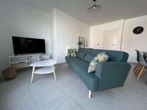 a living room with a blue couch and a tv at Appartement La Rochelle, 4 pièces, 8 personnes - FR-1-246-698 in La Rochelle