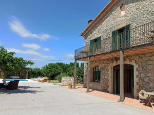 - un bâtiment en pierre avec un balcon à côté de la piscine dans l'établissement Casa Sant Pere Pescador, 5 dormitorios, 10 personas - ES-89-133, à Sant Pere Pescador