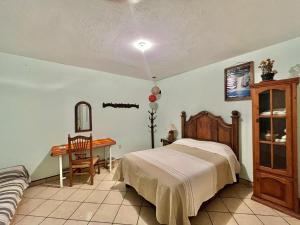 a bedroom with a bed and a desk and a table at Casa del Sol in Pátzcuaro