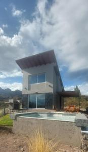 a house with a swimming pool in front of it at Ribera de Cacheuta Lodge in Las Compuertas
