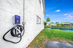 a hose is hooked up to a wall next to a pool at Stylish - Water View Condo - Palm Wave Says in Coconut Creek