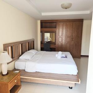 a bedroom with a large bed with a wooden headboard at Omni Suites 2Bedroom in Bangkok +23 photos
