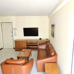 a living room with a couch and a flat screen tv at Omni Suites Serviced Apartment in Bangkok