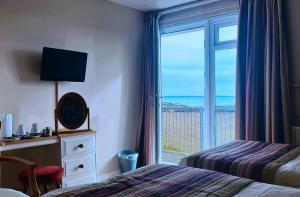 una camera d'albergo con finestra affacciata sull'oceano di Ocean Haze Hotel a St. Davids