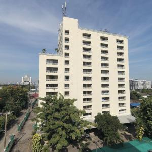 a large white building with trees in front of it at Omni Suites Serviced Apartment in Bangkok