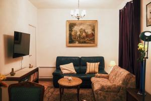 ein Wohnzimmer mit einem Sofa und einem Stuhl in der Unterkunft La Chouette - Appartement 70m2 PMR in Château-Thierry