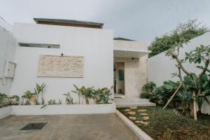 a white house with a courtyard with plants at The Pahala Villas in Nusa Dua