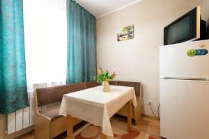 a small dining room with a table and a refrigerator at Nadezhda Apartments on Zhibek Zholy Avenue 33 in Almaty