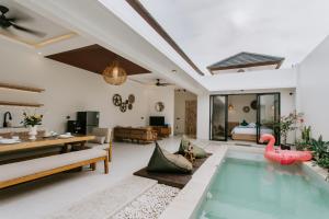 a villa with a swimming pool and a living room at The Pahala Villas in Nusa Dua