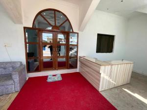 Habitación con alfombra roja y ventana grande. en PARI HOMESTAY en Khajurāho