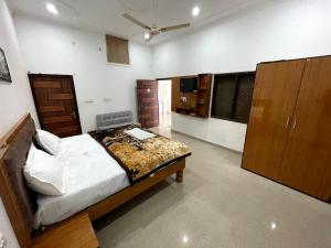 PARI HOMESTAY في خاجوراهو: غرفة نوم مع سرير في غرفة مع دواليب خشبية