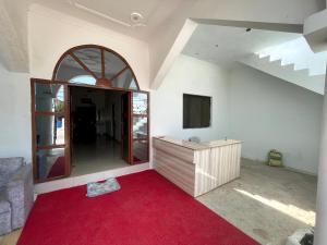 Habitación con alfombra roja y espejo grande. en PARI HOMESTAY en Khajurāho