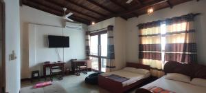 a bedroom with a bed and a desk and a tv at Trellis Homes in Colombo