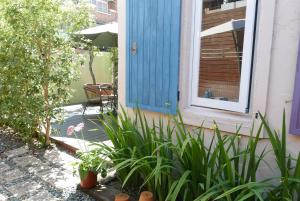 una puerta azul en el lado de una casa con plantas en Café des Mémoires兩條內褲南法鄉村民宿 en Puli
