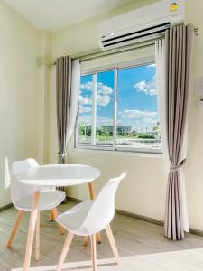 Habitación con mesa, sillas y ventana en At Pream&Chan resort แอท เปรมแอนด์จันทร์ รีสอร์ท 
